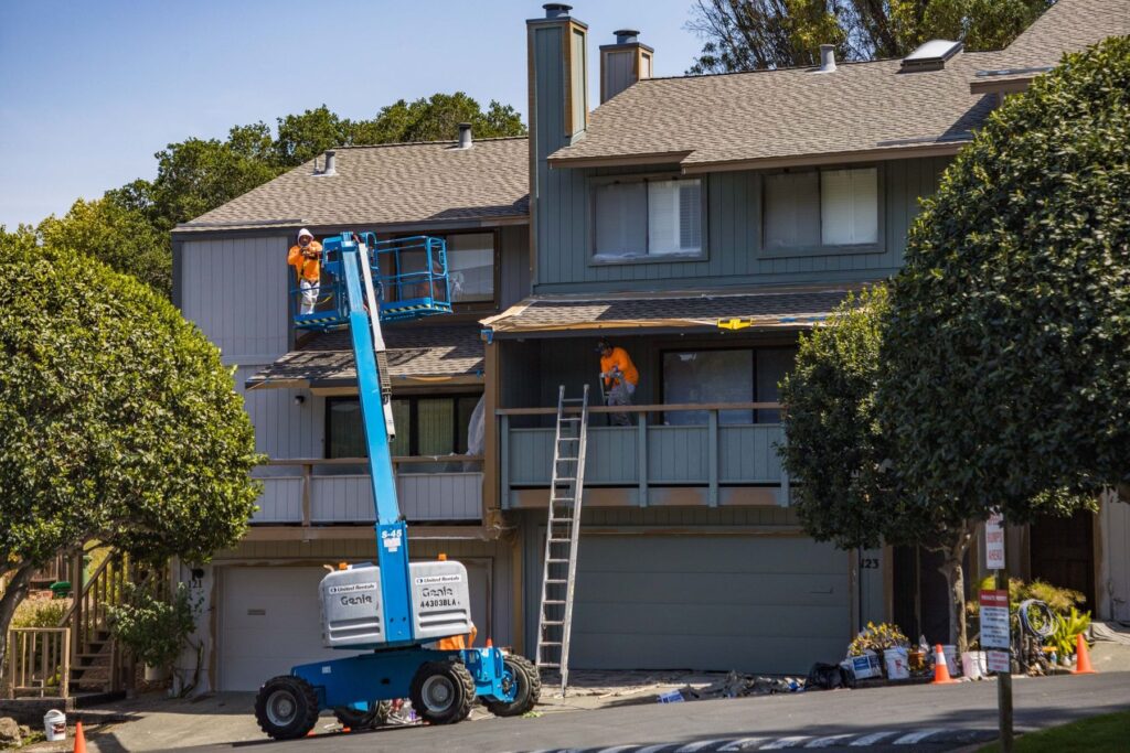 Townhouse block being repainted from an elevated work platform