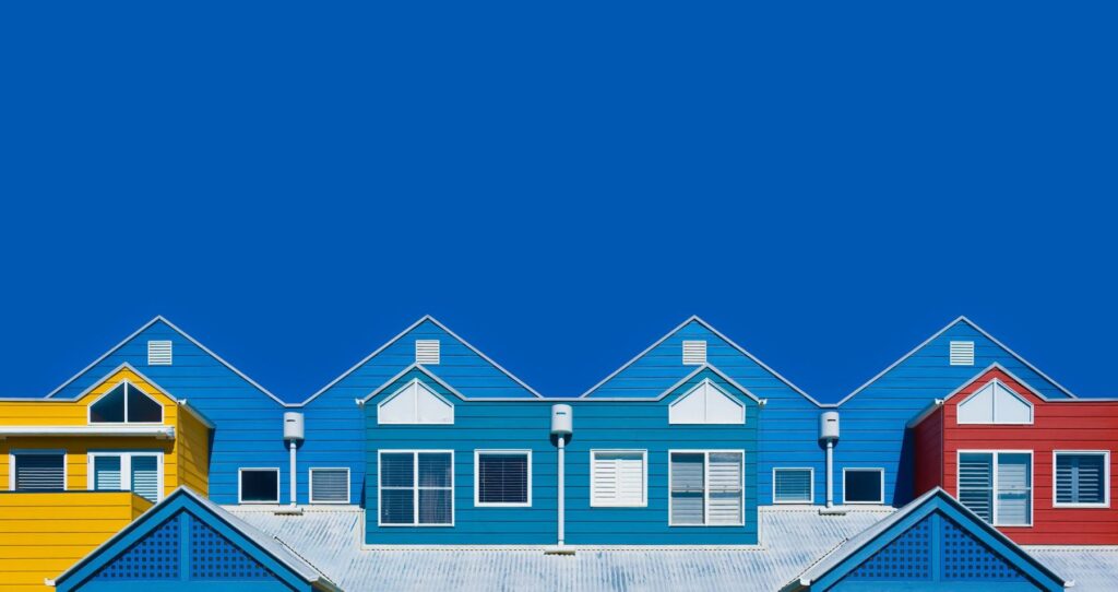 Row of weatherboard houses painted in bright blues and yellow