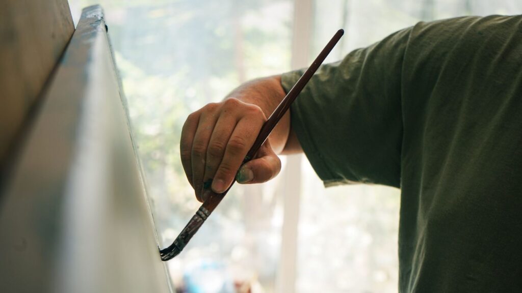 Painter cutting in a straight line with a fine brush
